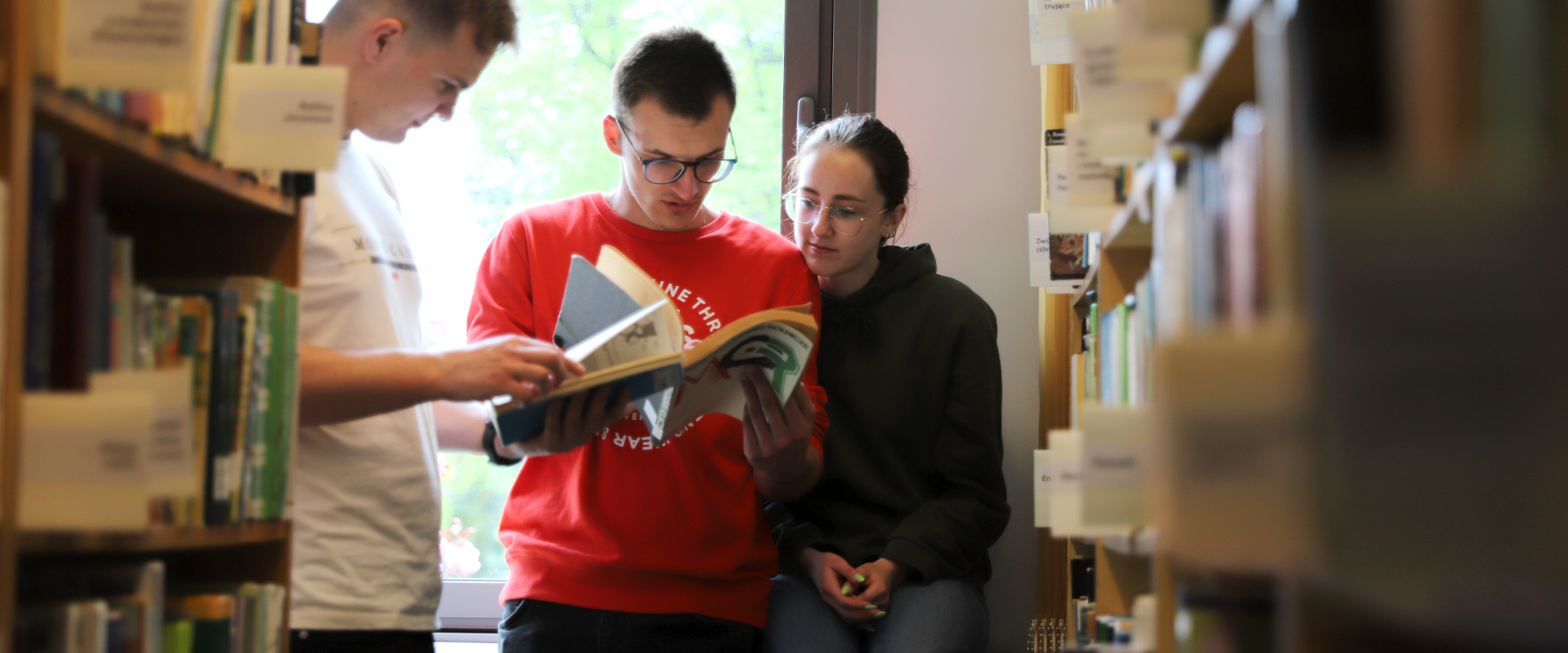 studenci czytają książki w bibliotece 