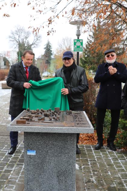 Grupa osób przygląda się makiecie kampusu UPP wykonanej z brązu