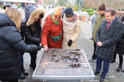 Grupa osób przygląda się makiecie kampusu UPP wykonanej z brązu