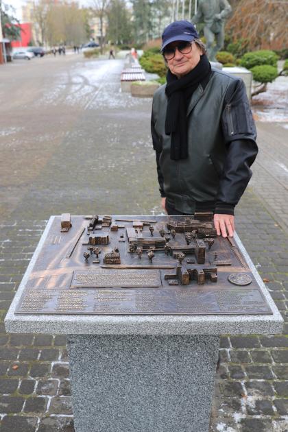 Mężczyzna oparty o makietę kampusu UPP wykonaną z brązu