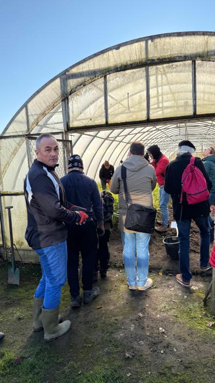 Grupa osób wchodząca do szklarni