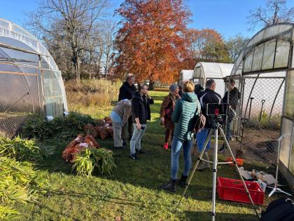 Grupa osób przed szklarnią
