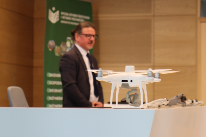 dron, w tle mężczyzna podczas prezentacji