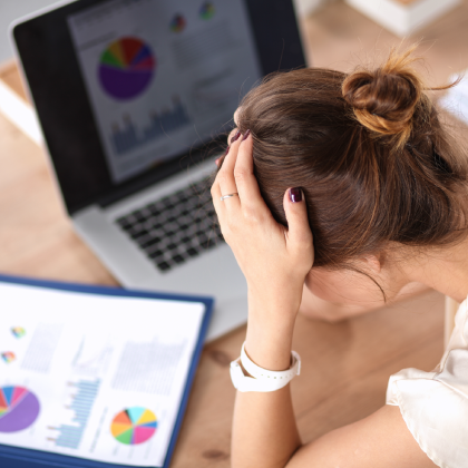 Portret zmęczona młoda biznesowa kobieta z laptopem przy biurem