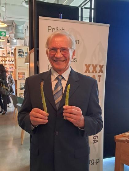 Mężczyzna trzyma w dłoniach szparagi