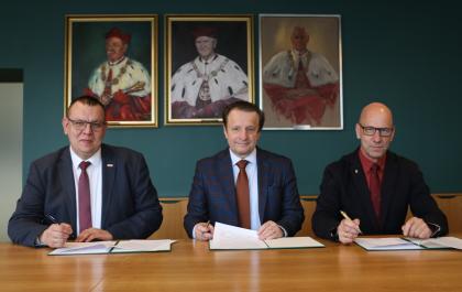 Trzy osoby podczas podpisywania porozumienia