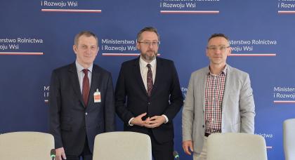 Trzech mężczyzn na tle ścianki