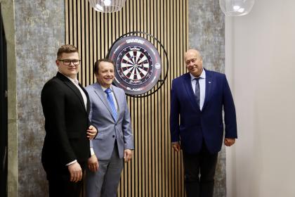 Trzech mężczyzn przy tablicy do darta