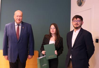 Wręczenie dyplomów, trzy osoby podczas pamiątkowego zdjęcia