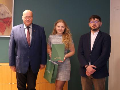 Wręczenie dyplomów, trzy osoby podczas pamiątkowego zdjęcia