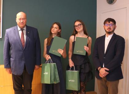 Wręczenie dyplomów, cztery osoby podczas pamiątkowego zdjęcia