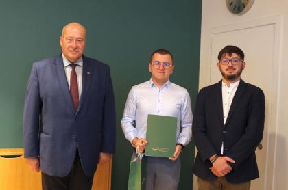 Wręczenie dyplomów, trzy osoby podczas pamiątkowego zdjęcia