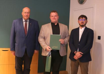 Wręczenie dyplomów, trzy osoby podczas pamiątkowego zdjęcia