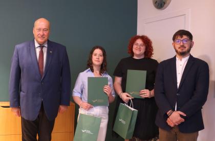 Wręczenie dyplomów, cztery osoby podczas pamiątkowego zdjęcia