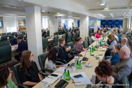Grupa osób w sali podczas obrad