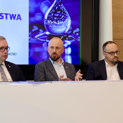 trzech mężczyzn podczas debaty w sali wykładowej