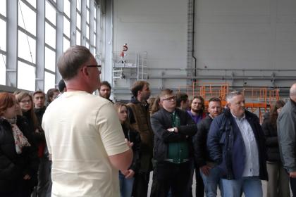 grupa osób zwiedzająca hangary lotnicze