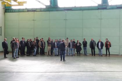 grupa osób zwiedzająca hangary lotnicze