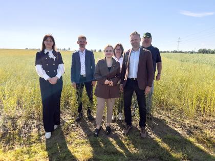 Grupa osób, w tle pola uprawne