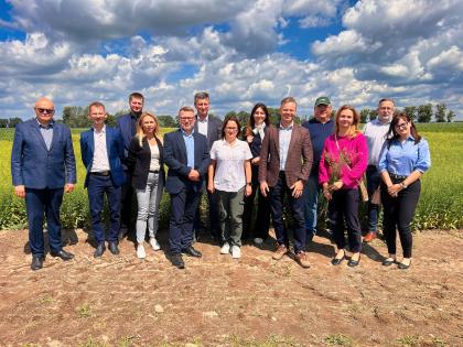 grupa osób, w tle pola uprawne