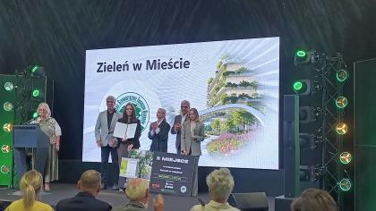 grupa osób na scenie podczas odbierania nagrody