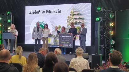 grupa osób na scenie podczas odbierania nagrody