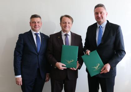 trzy osoby podczas podpisania dokumentu