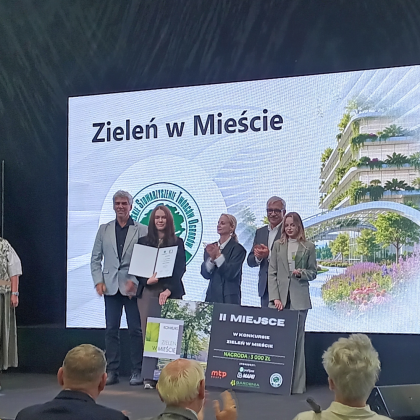 grupa osób na scenie podczas odbierania nagrody